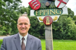 Dr Neil Hudson standing in front of Epping sign 