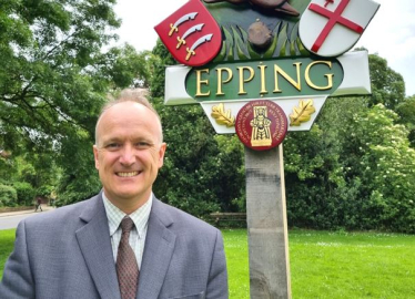 Dr Neil Hudson standing in front of Epping sign 